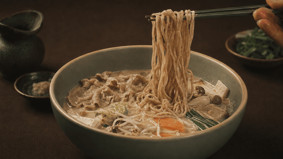 Shabu beef and veggies in a creamy sesame broth with KYUNU chuka soba noodles being lifted with chopsticks