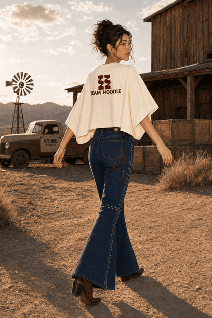 Model from behind in the cream Kyunu batwing tee and flared jeans by a Kyunu Noodle Co. pickup truck