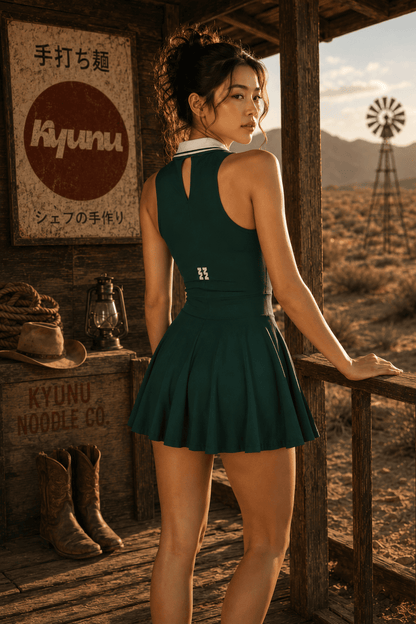 Rear view of the green Kyunu tennis dress worn on the porch, showing the keyhole back and logo