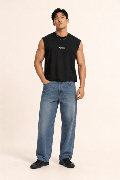 Model in a black Kyunu Team Noodle terry boxy tank top with raw-cut hem, worn with wide-leg jeans